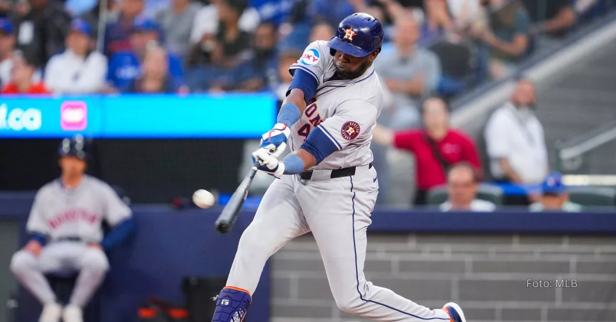 Yordan Alvarez haciendo swing y chocando la bola con el uniforme gris de Houston Astros